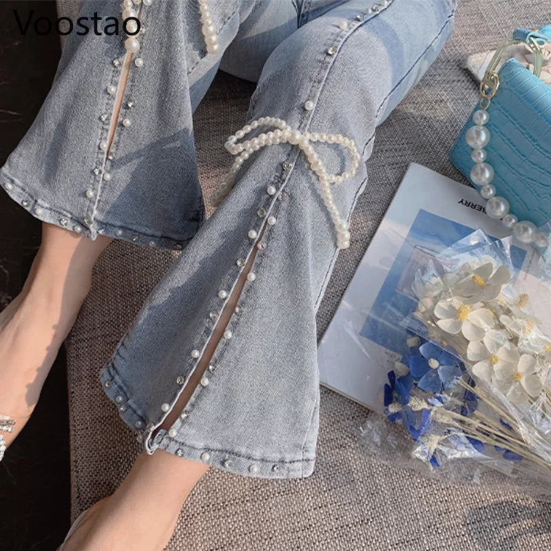 Light blue jeans with pearl embellishments on a textured surface.
