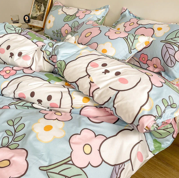 Cute bedding with bunnies and pink flower design with a nightstand next to it