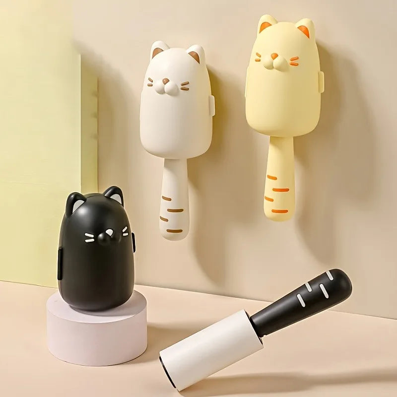 Three cat-shaped hairbrushes in black, white, and yellow on a beige background