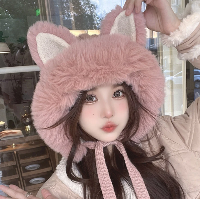 Person wearing a pink fluffy kawaii hat with cat ears indoors