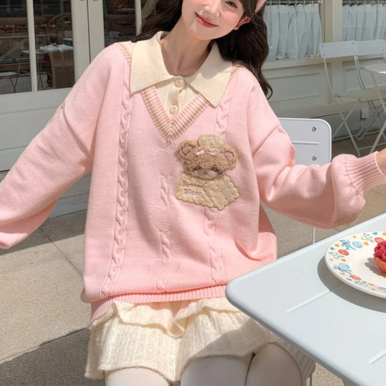 Woman wearing a pink sweater with a bear design outdoors