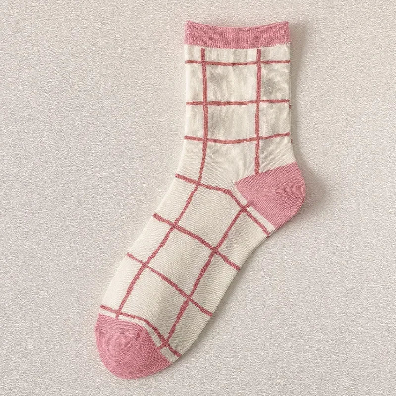 White sock with pink grid pattern and pink toes and cuffs on a light gray background