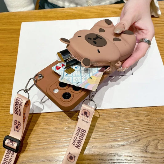 Dark Brown Capybara-shaped phone case with strap on a wooden surface