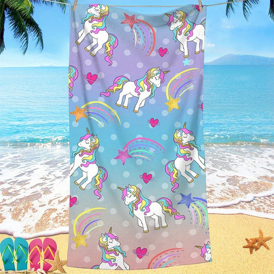 Unicorn-themed towel with colorful patterns on a beach background