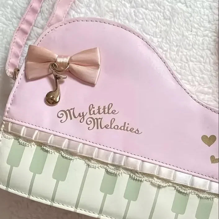 Kawaii pink bag with a bow and 'My little Melodies' text, featuring piano keyboard design.