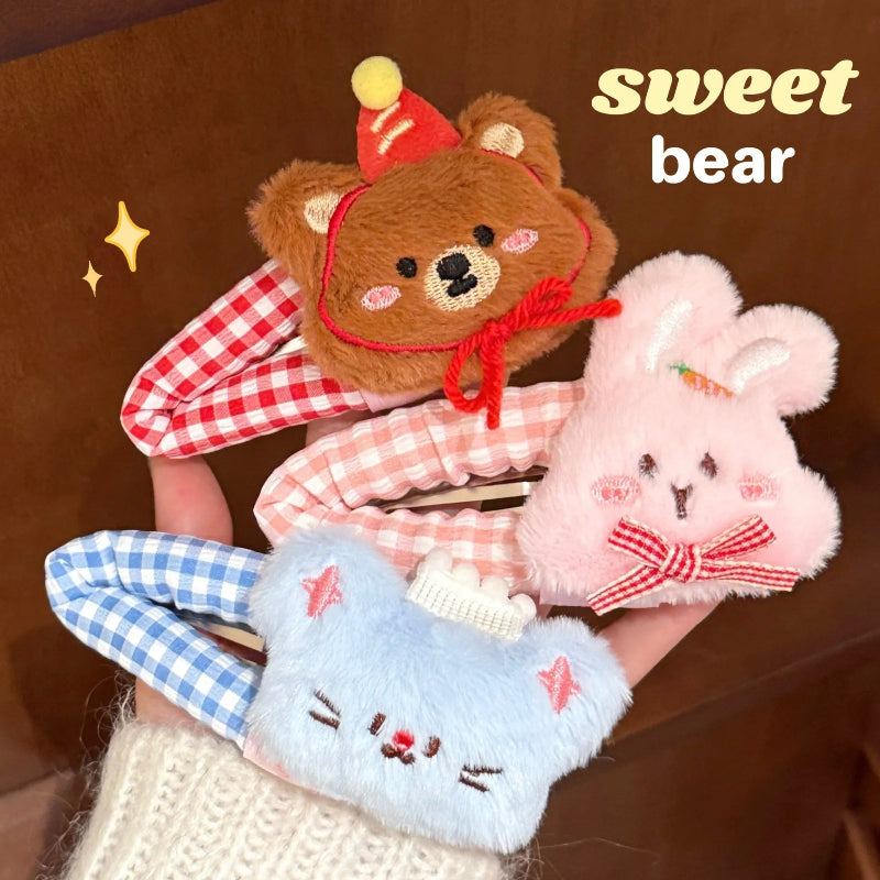 Three plush kawaii animal hair clips on a brown background.