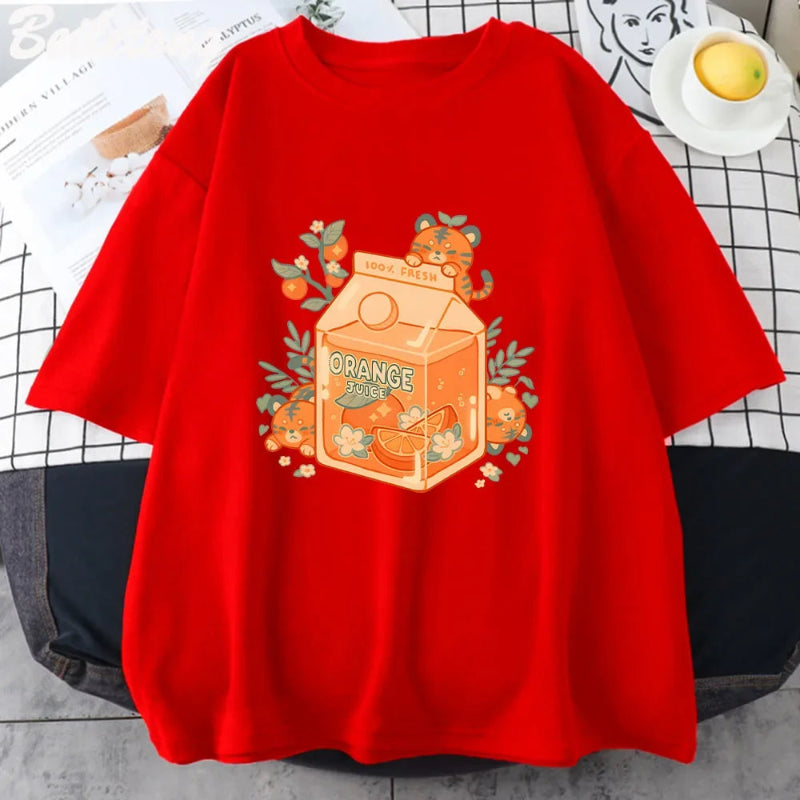 A red t-shirt with an illustration of a tiger character drinking orange juice from a carton, surrounded by oranges and green leaves.