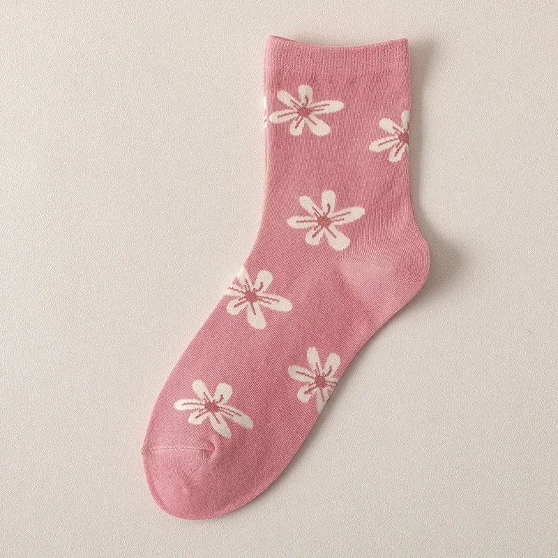 Pink sock with white floral patterns on a beige background
