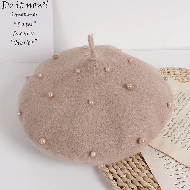 Beige beret with pearl embellishments on a white surface with text overlay.