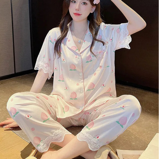 A woman is displaying the Cute Peach Print Lace Trim Pajamas, this is the set that has trousers.