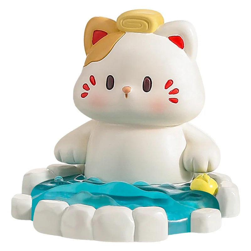Cute resin figurine of a cat in a onsen with a yellow towel on its head on a white background.