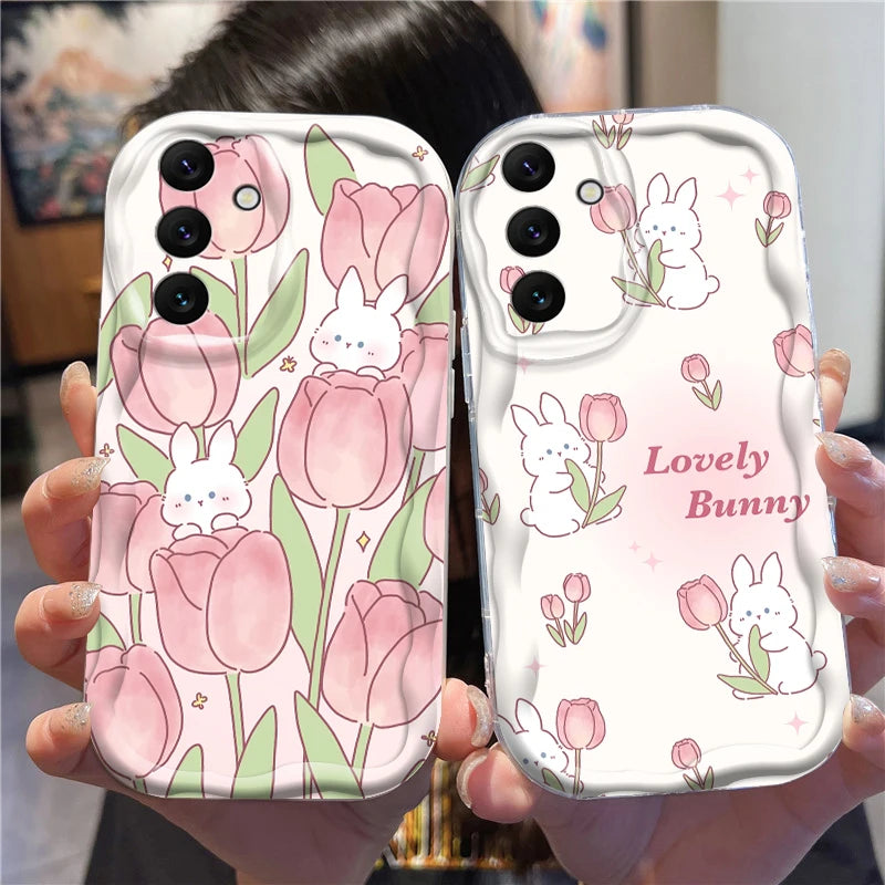 Two phone cases with floral and bunny designs held by a person.