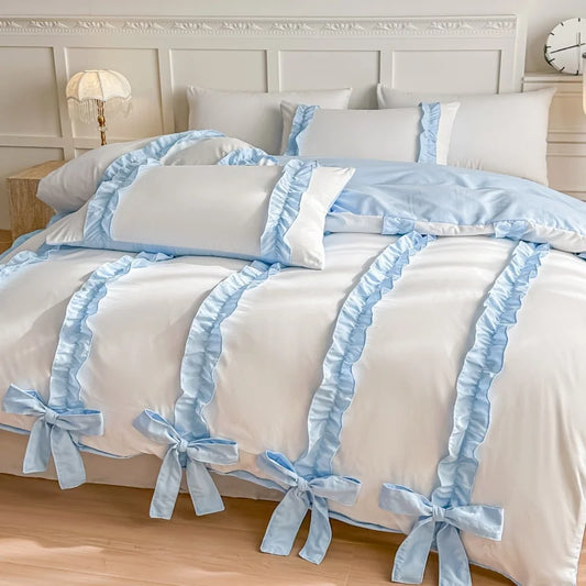 White duvet cover with Blue bows and ribbons on a bed in a bedroom setting.