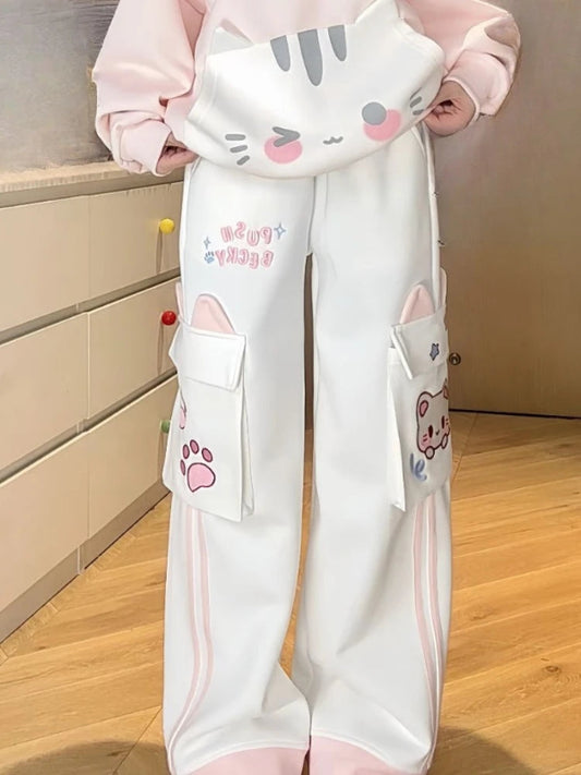 White pants with cat designs on a wooden floor.