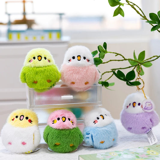 Set of colorful bird plushie keychains on a surface with a blurred indoor background.
