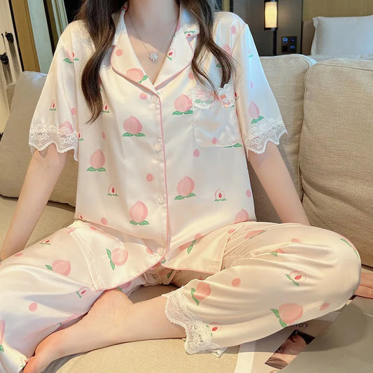 woman wearing Cute Peach Print Lace Trim Pajamas, the set that contains the trousers, she is wearing them on a sofa.