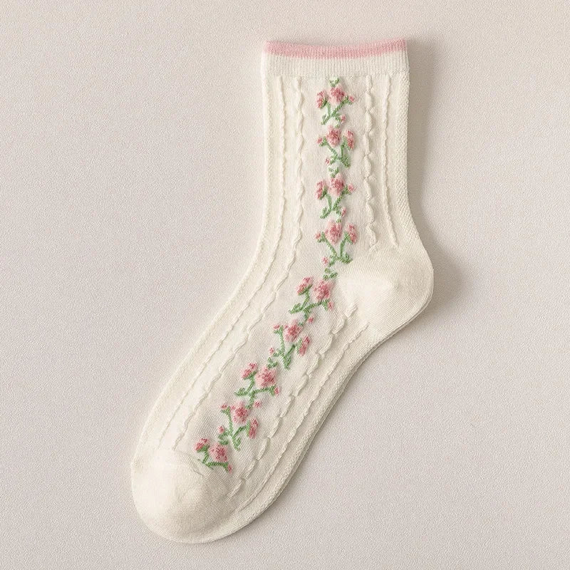 White sock with floral embroidery on a light gray background