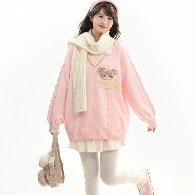 Person wearing a pink sweater with a bear design, white scarf, and white skirt on a white background.