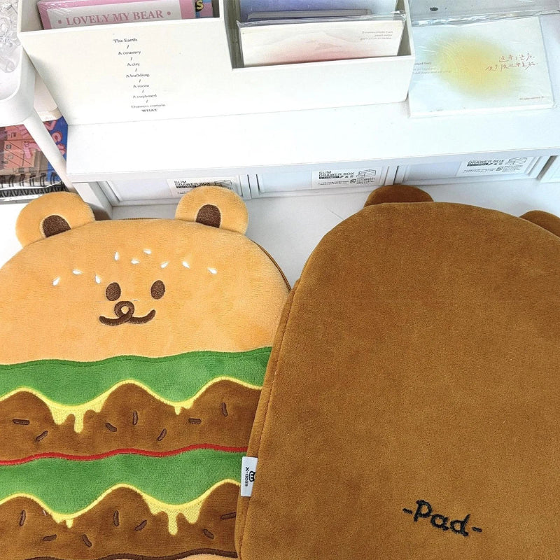 Two brown bear hamburger-shaped laptop sleeves with a visible brand logo on a desk