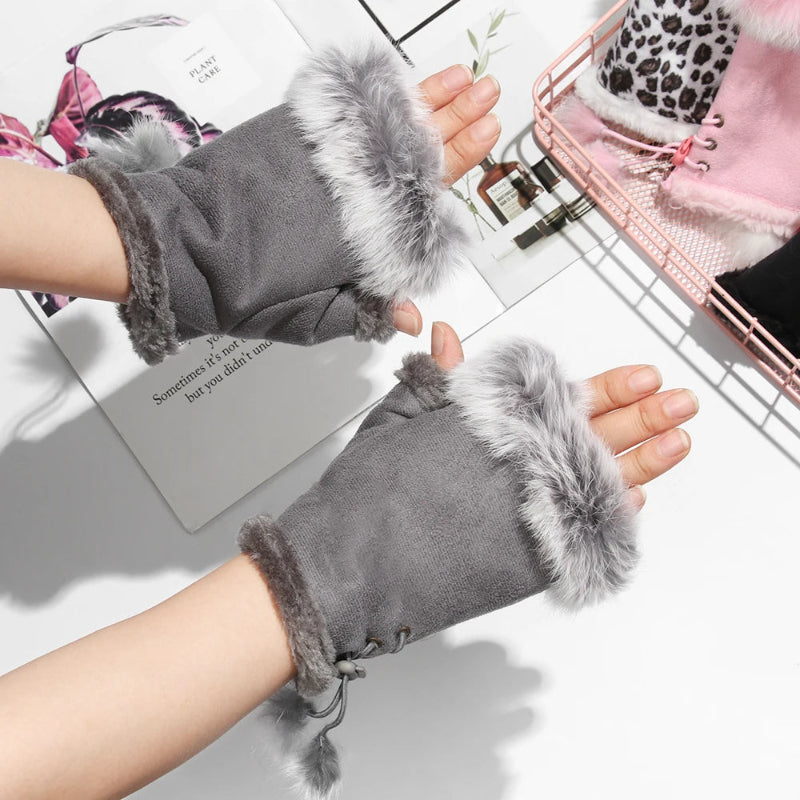 Gray gloves with fur trim worn on hands against a light background