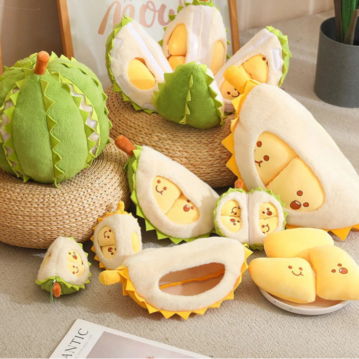 Plush toys resembling durian fruits on a textured surface with 'Zö' branding.