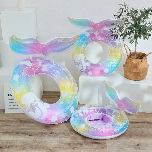 Colorful inflatable mermaid tail on a wooden surface with a plant and books in the background.