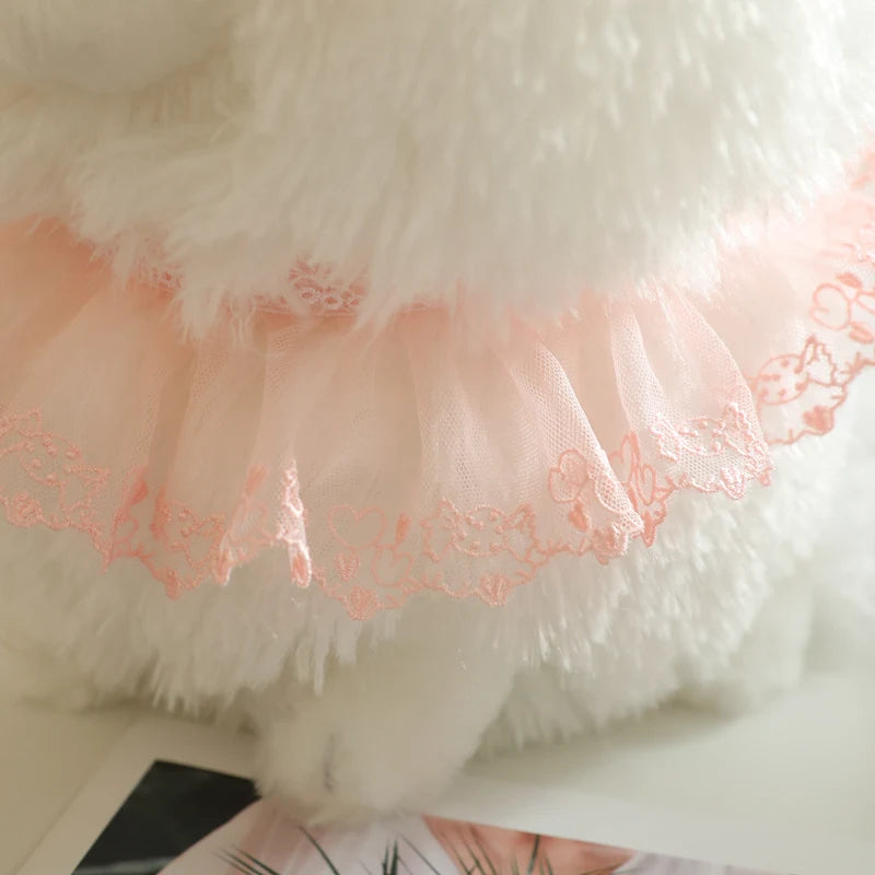 Close-up of a fluffy white plushie fabric and and pink lacy collar ruffle