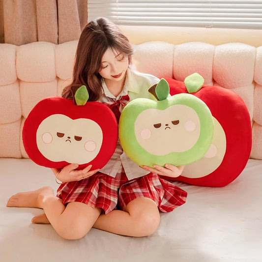 Person holding two plush apple toys on a couch