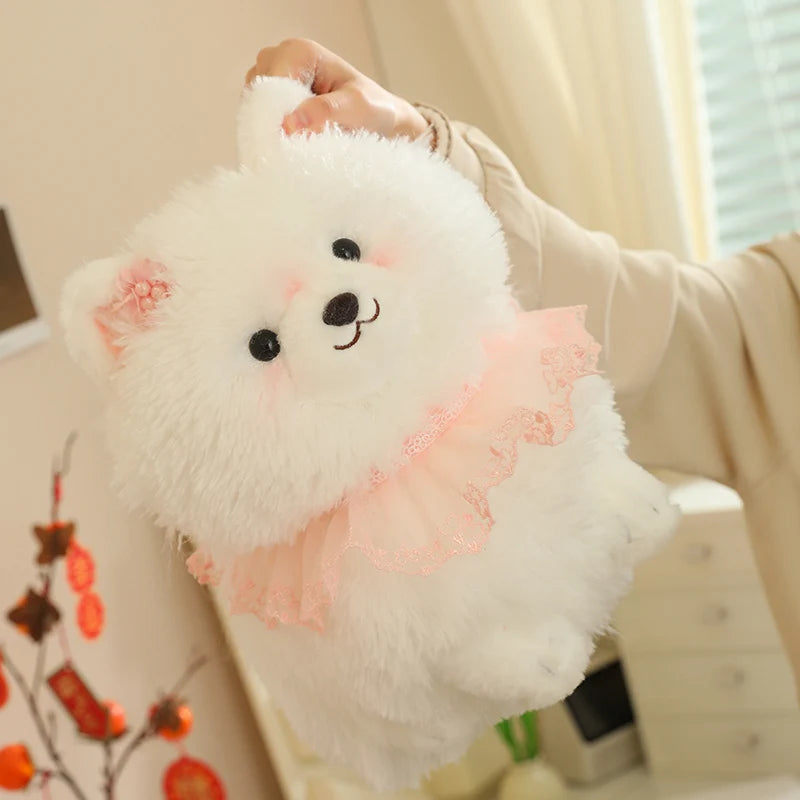 White pomeranian plush toy with pink accents held by a person indoors