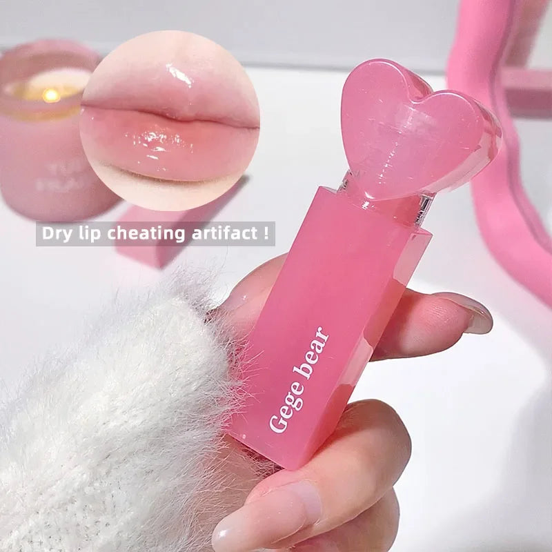 Pink lip balm with heart-shaped design held by a hand, close-up of lip balm on white surface.