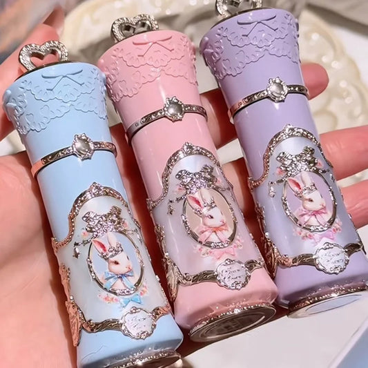 Three lovely lip balms with rabbit illustrations on a hand.