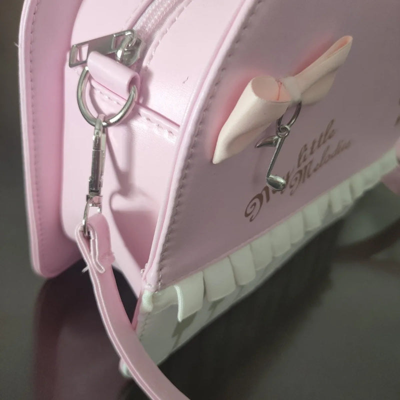 Pink handbag with a keychain and decorative bow on a dark background