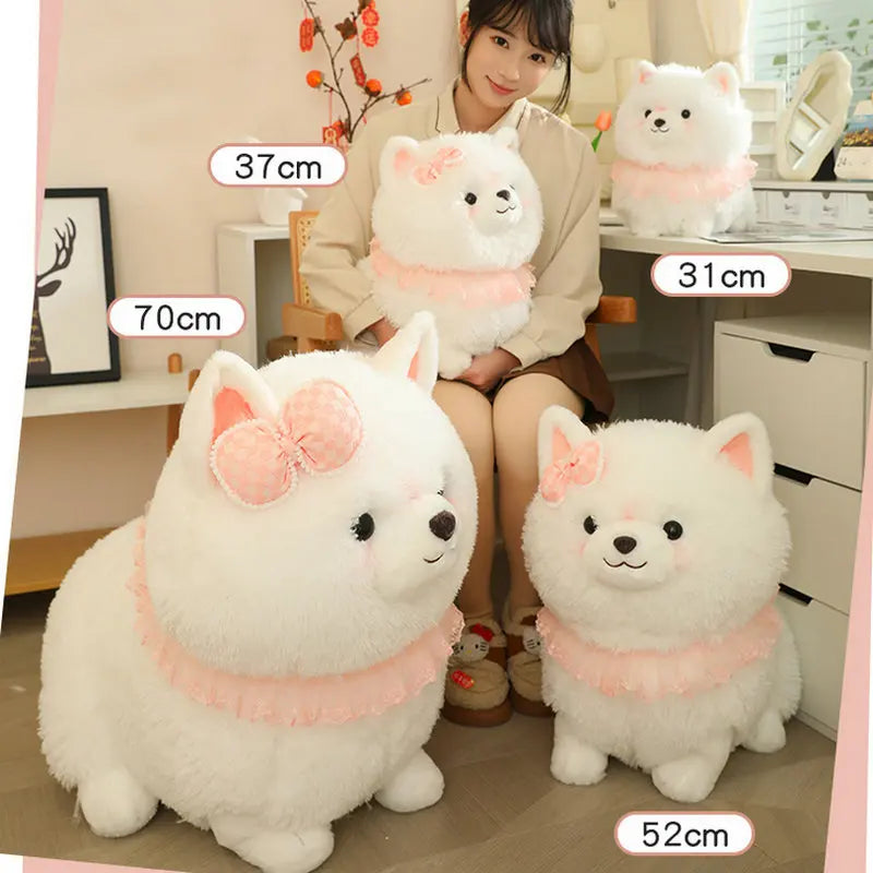White plush dog toys displayed in front of a person holding a smaller plush toy.