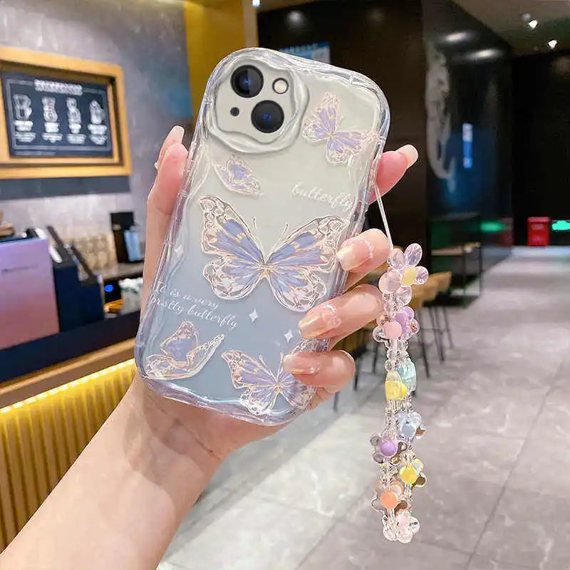Phone case with butterfly design held by a hand in an indoor setting