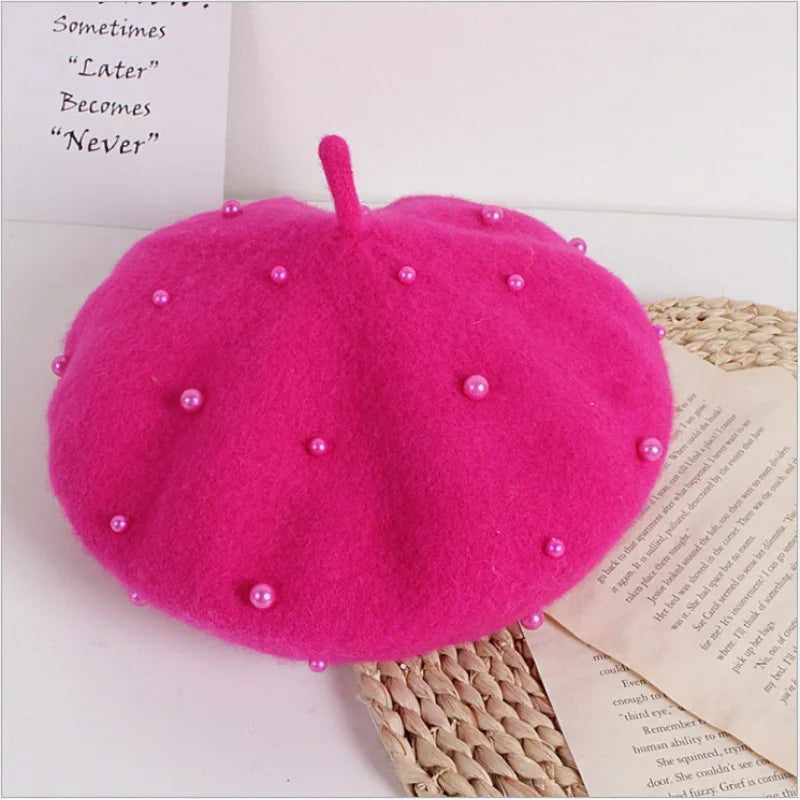 Hot Pink beret with pearl embellishments on a white surface with text and wicker mat.