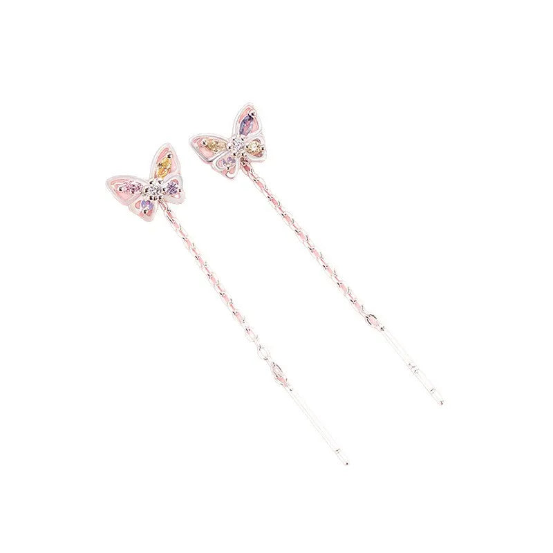 A pair of long, dangling butterfly hair pins in a light pink metallic finish with iridescent pastel-colored rhinestones on the butterfly wings, shown on a plain white background.