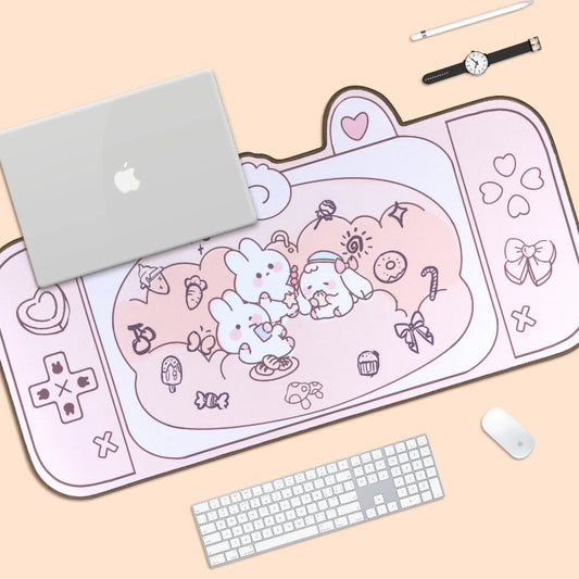 Pink kawaii-themed mouse pad with a laptop, keyboard, and mouse on a beige surface