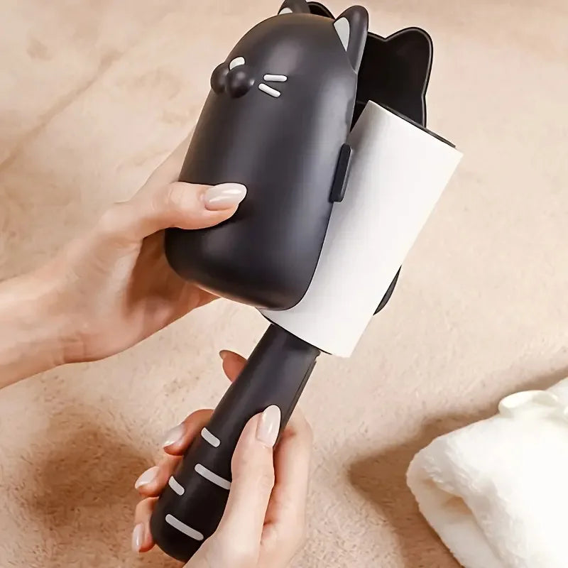 Person holding a black lint roller with a cat design on a beige background