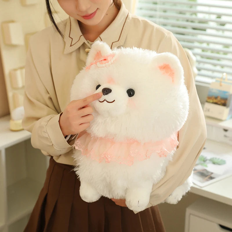 Person holding a fluffy white pomeranian plushie tby a window