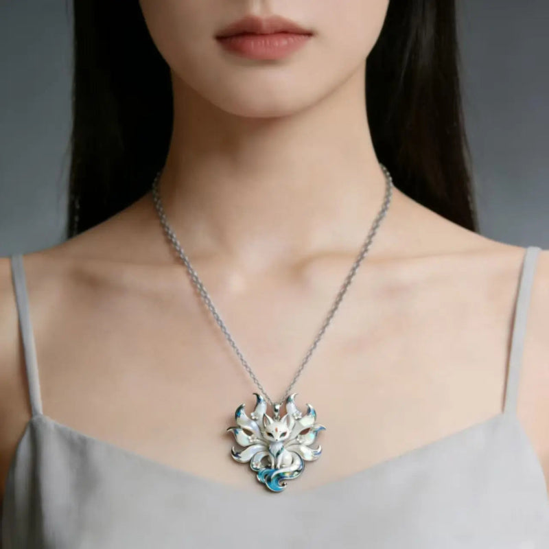 Woman wearing a silver Kitsune necklace with a detailed pendant against a neutral background