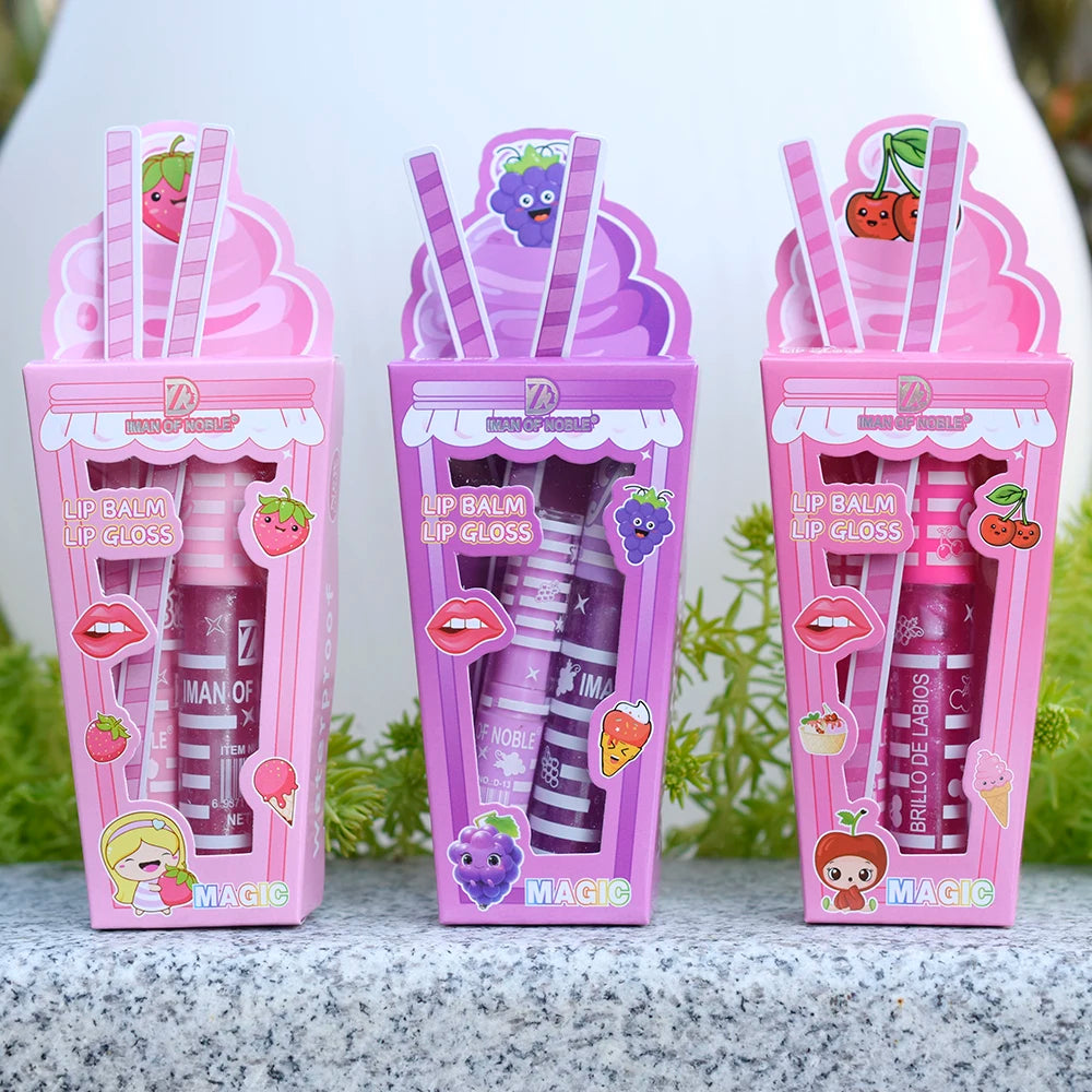 Three lip balm and lip gloss packages with colorful designs on a gray surface.