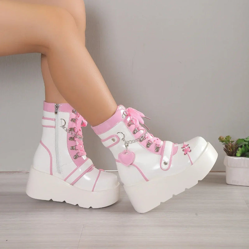 White platform boots with pink accents worn by a person on a neutral background