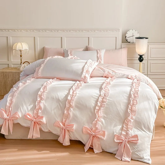 White bedspread with pink ruffles and bows in a bedroom setting.