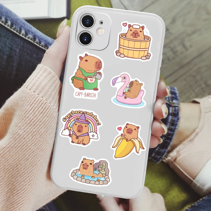 Phone case with cartoon capybara designs held by a person