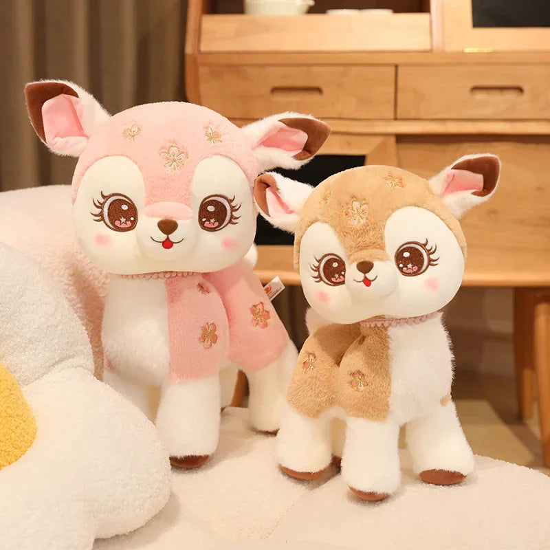 Two kawaii plush deer toys with pink and brown colors on a light-colored surface.