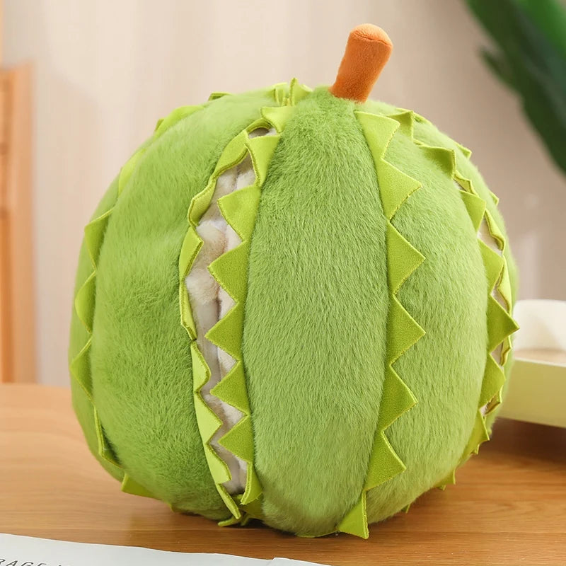 Green plush toy resembling a durian on a wooden surface with a blurred background