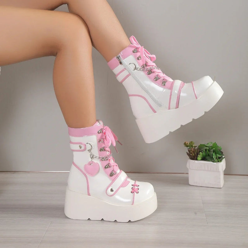 White platform boots with pink accents worn by a person, on a neutral background.