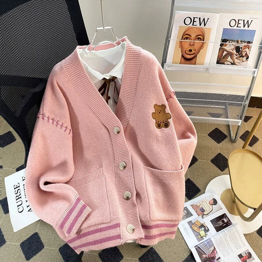 Sweet Teddy Bear Cardigan pastel pink edition with a bear sown into the chest area whilst the sleeves have large black stitches where they have been joined and black strips on the wrist cuffs and black and pink trim