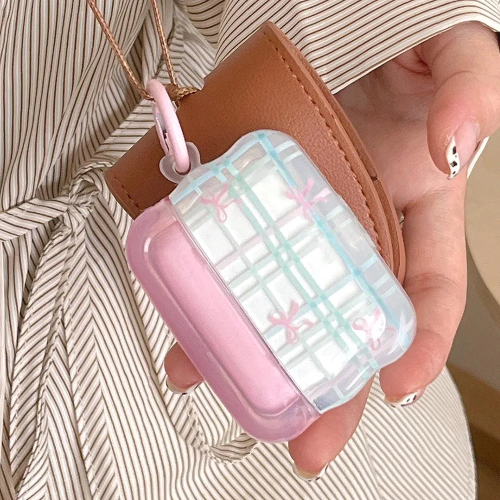 Person holding a pink and clear airpod case with a strap