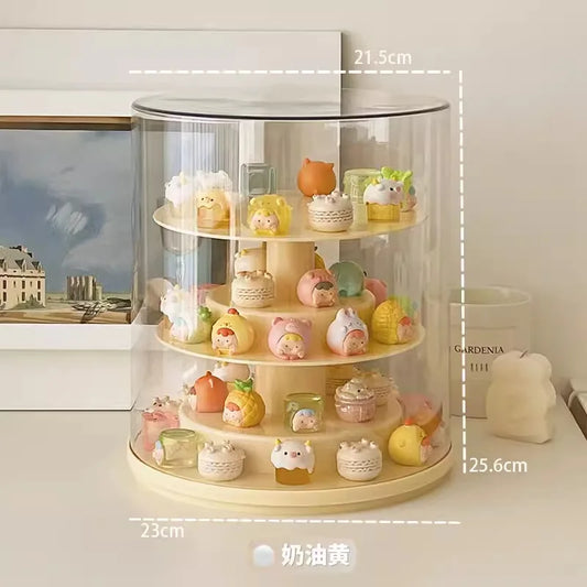 A 4-tier rotating acrylic display stand with a clear cylindrical dome cover and cream-colored base, shown on a tabletop with dimension labels overlaid (21.5 cm top, 25.